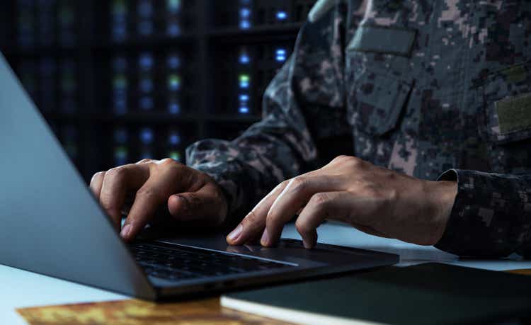 Soldier in camouflage uniform working on laptop for Information
