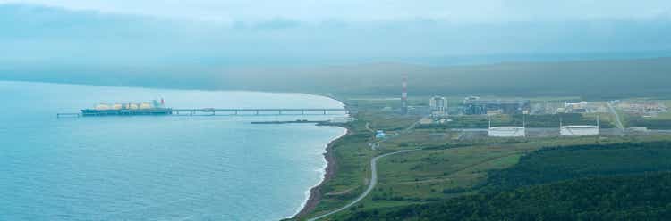 Liquefied natural gas plant in the coastal valley and offshore LNG terminal with a tanker under loading in Prigorodnoye, Sakhalin, aerial panorama
