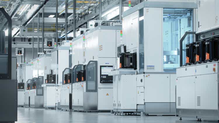 Wide shot of Bright Advanced Semiconductor Production Fab Cleanroom with Working Overhead Wafer Transfer System