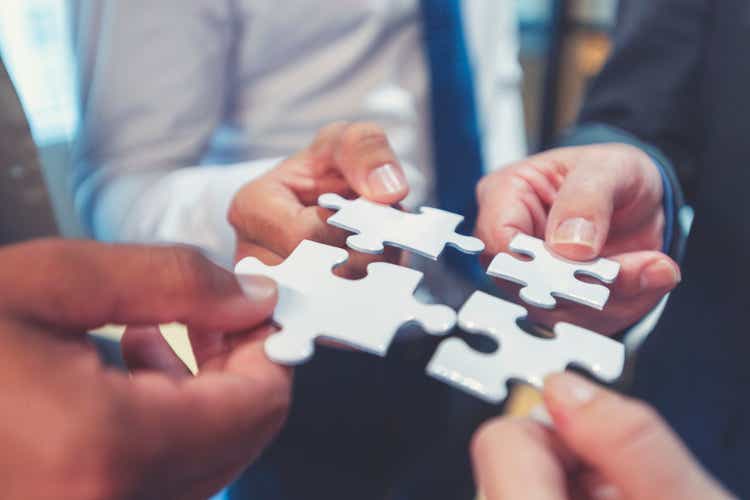 Group of business people holding a jigsaw puzzle pieces.