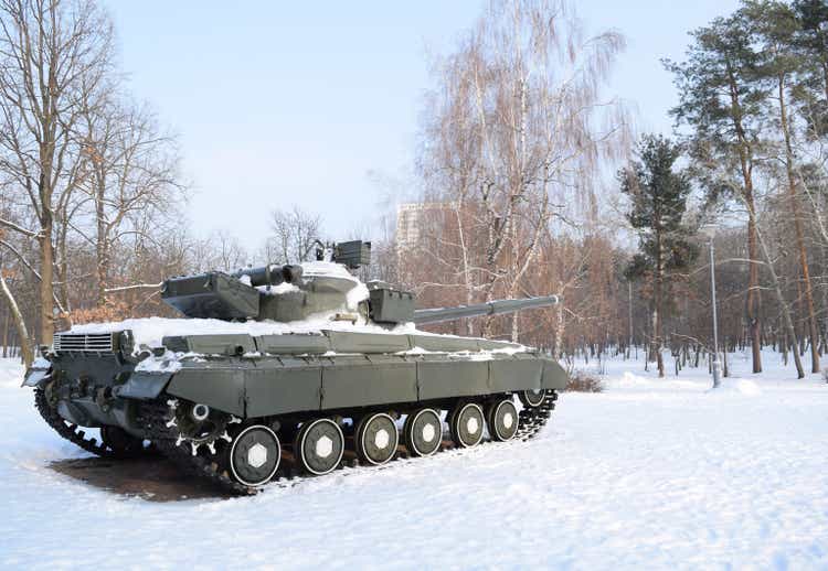 A large military tank stands in a winter forest. tank in the snow. Tank in winter