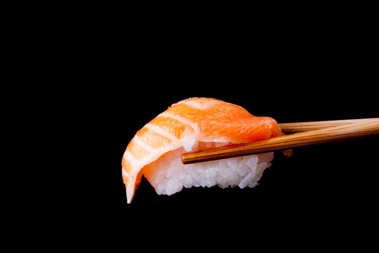 Salmon sushi by wooden chopsticks