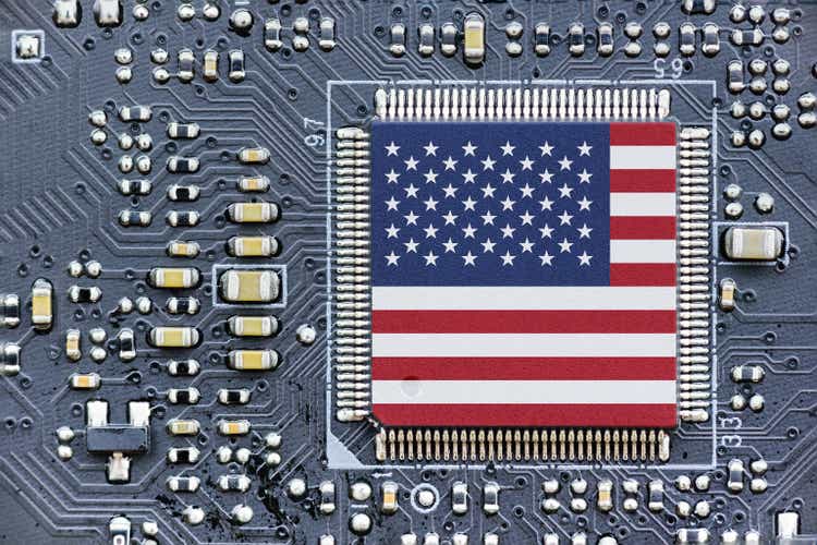 Flag of USA on a processor, CPU Central processing Unit or GPU microchip on a motherboard. Congress passes the CHIPS Act of 2022 to strengthen domestic semiconductor manufacturing, research and design.