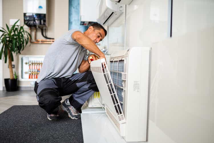 Technician cleaning air conditioner filter