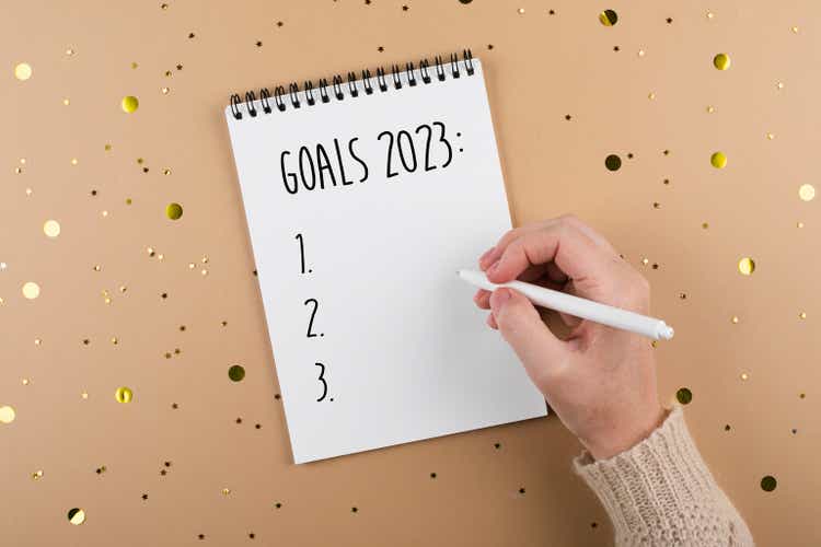 New Year goals 2023. Woman"s hand writing in note pad goals list. Concept of new year planning