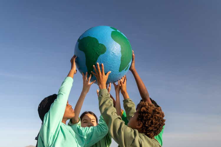 Group of children working together to hold up the world