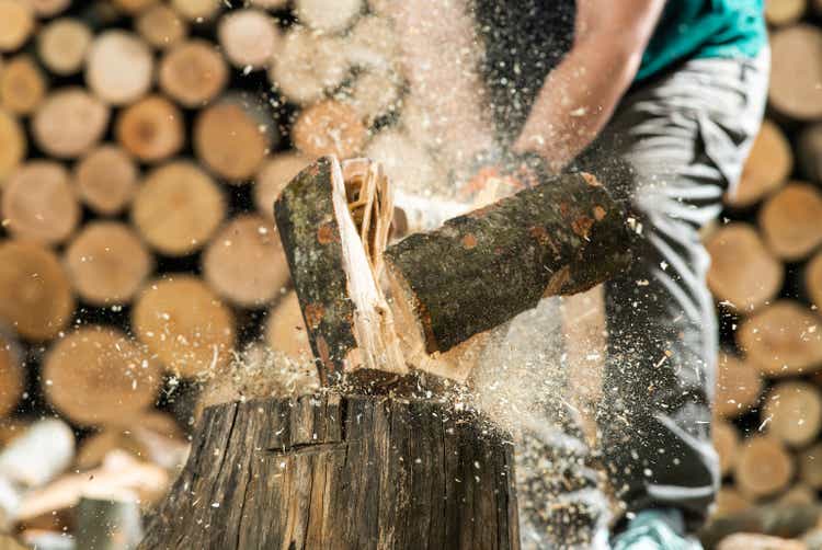 Hand and axe in firewood,