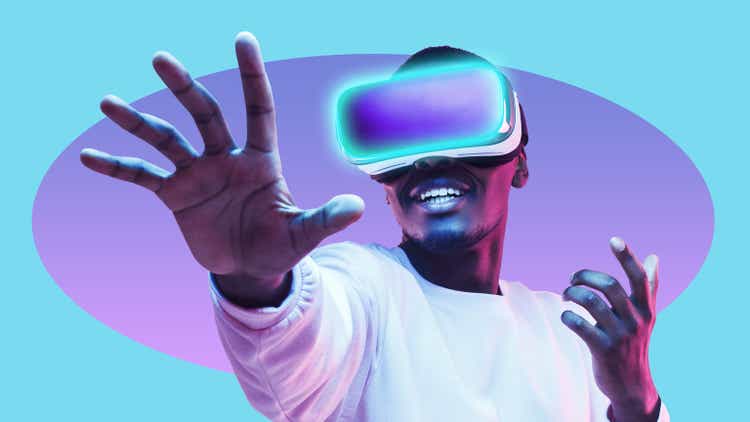 African american man in vr headset exploring metaverse world, touching virtual reality subjects