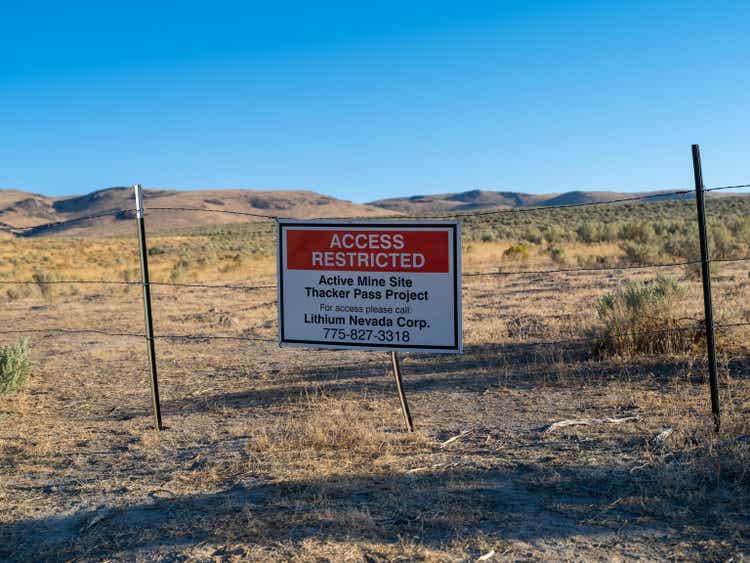 Warning sign on barbed wire fence