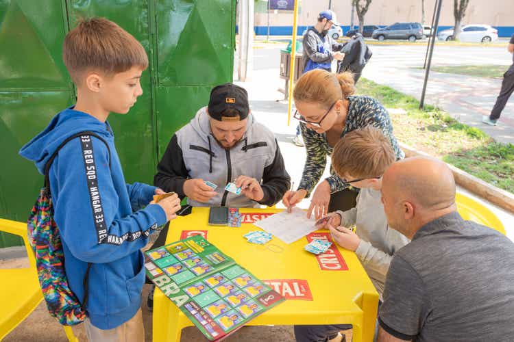 Parents and children passionate about soccer exchange stickers from the Panini album