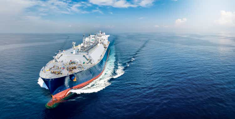 Front view of a big LNG tanker ship traveling with full speed over the calm, blue ocean