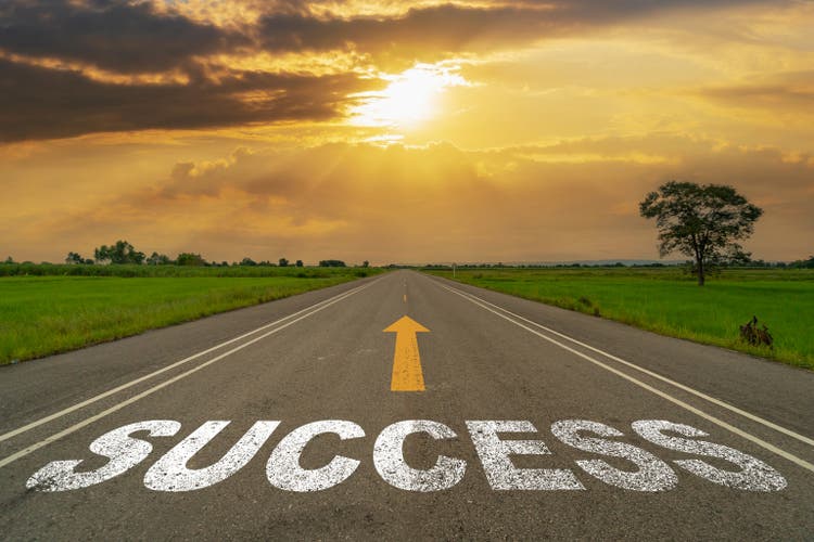 Success on highway road of empty asphalt road at beautiful sunset.