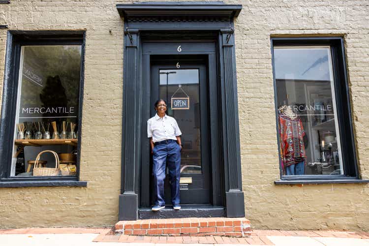 Portrait of female small business owner in front of her store