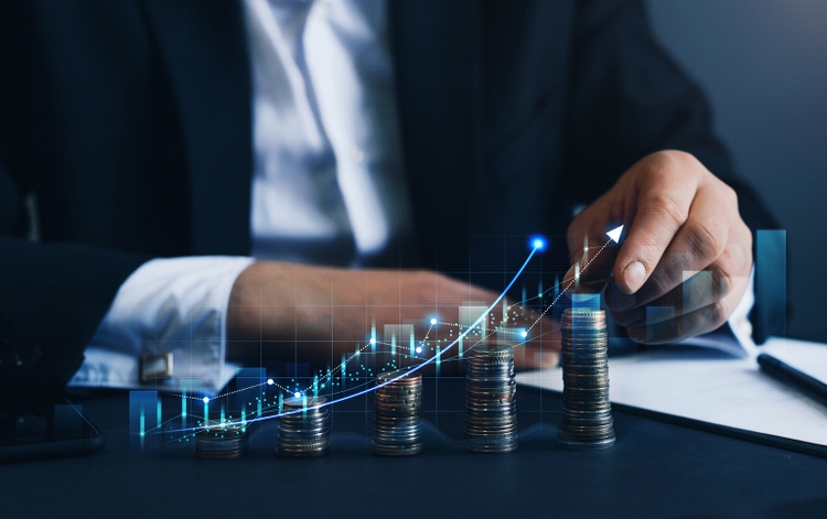 Hand putting money coin stack with growing business graph. Saving money concept. Stock market and business investment.