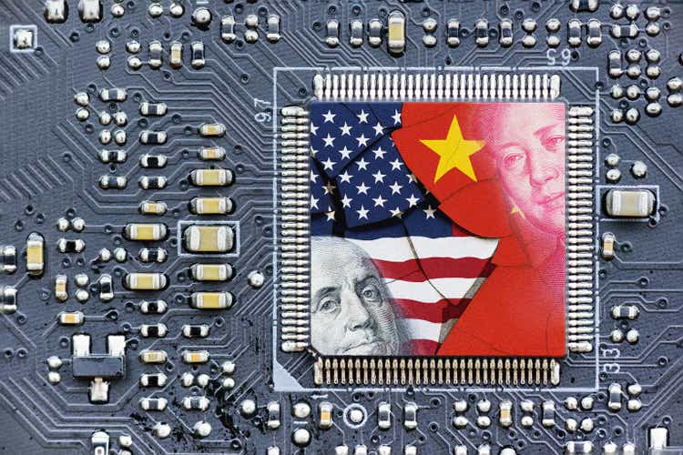 Flag of USA and China on a processor, CPU or GPU microchip on a motherboard. US companies have become the latest collateral damage in US - China tech war. US limits, restricts AI chips sales to China.