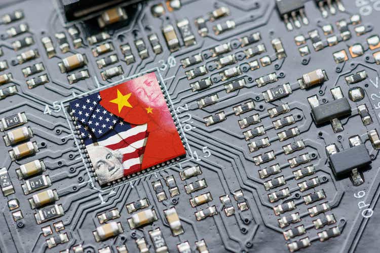 Flag of USA and China on a processor, CPU or GPU microchip on a motherboard. US companies have become the latest collateral damage in US - China tech war. US limits, restricts AI chips sales to China.