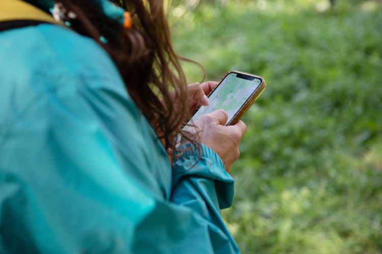 A woman looks at her phone for directions in rural setting