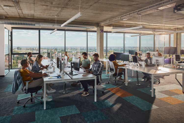 Multi-tasking computer programmers working in a modern office.