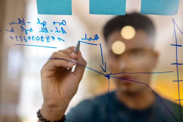 Business man drawing statistics on glass board