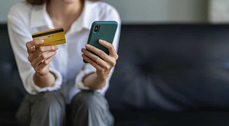 woman using smartphone Pay and hold credit card online shopping.