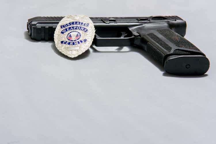 Gun with badge on white background