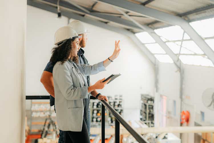 Factory, woman and manager on tablet with employee planning checklist logistics or stock. Collaboration, warehouse and industrial worker on tech working in manufacturing and distribution job site.