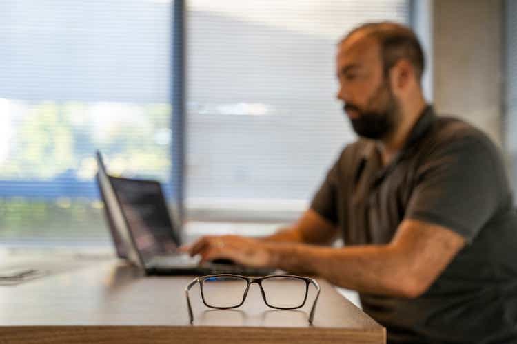 The only software engineer working in a modern office is making new software.