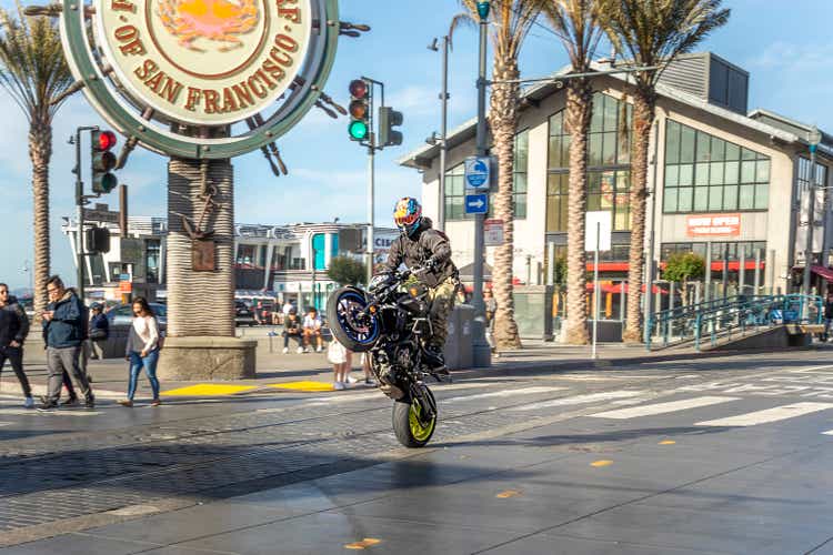 motorbike rider shows a Wheelie at his bike downtown at fisherman"s wharf