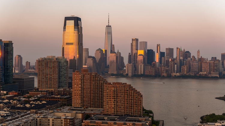 Paulus Hook in Jersey City with Goldman Sachs Tower and Lower Manhattan distant view, over the Hudson River at sunset.