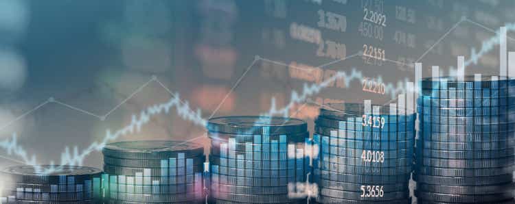 financial chart with uptrend line graph of stock market and stack of coins background