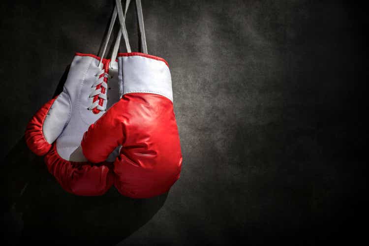 Boxing gloves hanging on wall with grunge gray background and copy space