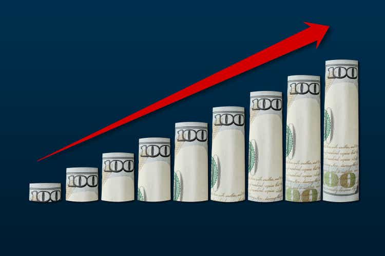 Rolled up dollar bills in an ascending chart with a red up arrow. Business success concept, financial growth chart, goal achievement, analytics