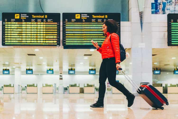 Woman using smartphone at the airport terminal