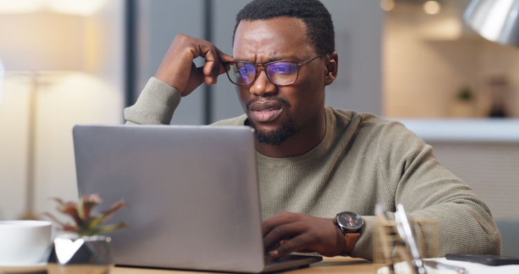 Anxiety, stress and confused man on a laptop in home office, worry and anxious about an online project deadline. Glitch, 404 and system error delay with black business man working remote, frustrated