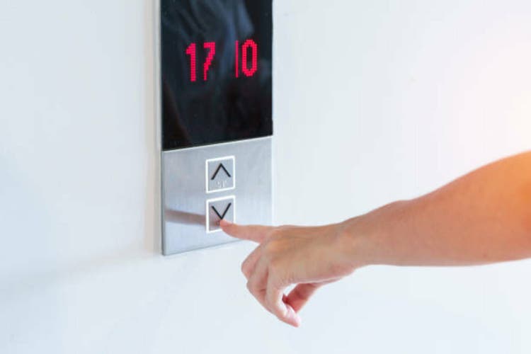 Hand finger press the Elevator button, woman waiting for Elevator in office or apartment