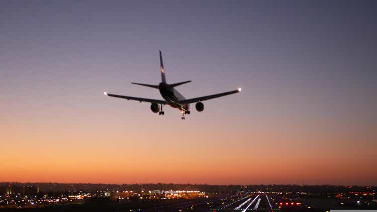Airport runway lights at night, plane or airline landing to airstrip at sunset.