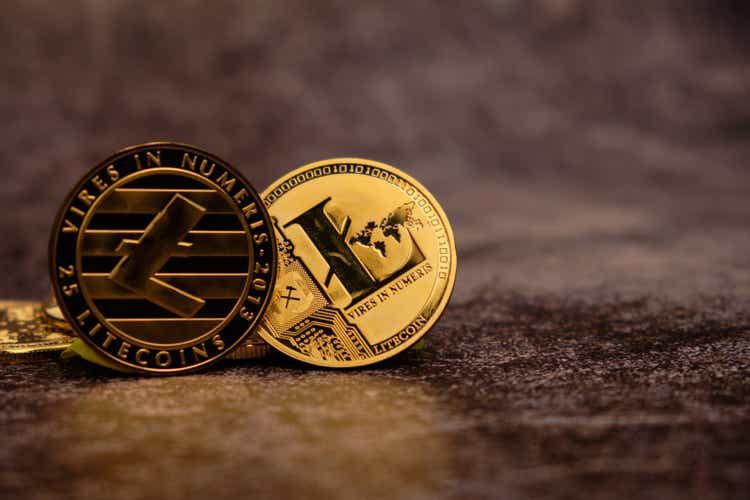 Close-up of the Litecoin Cryptocurrency with a golden reflection on the table.
