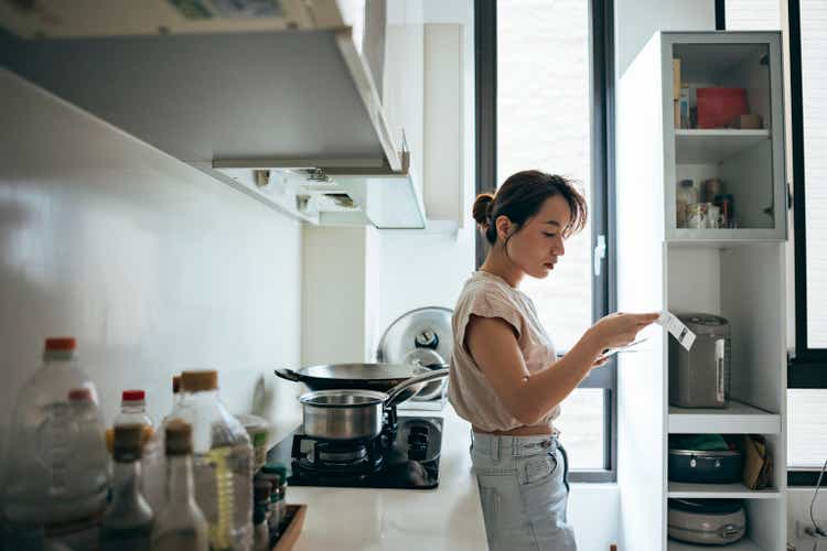 Asian women examining the shopping receipt at home