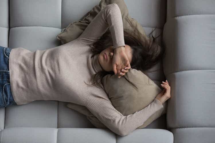 Peaceful girl lying on her back on a comfortable sofa at home