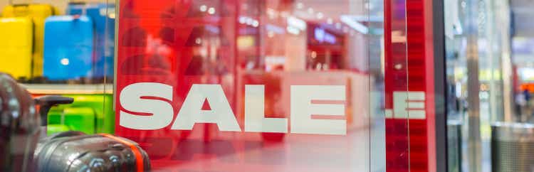 Discount percentage sign display in fashion department store during sale season period. Sale tag of offering special promotion hanging in shopping mall, web banner.