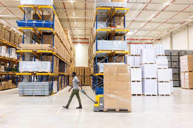 Workers moving cargo in distribution warehouse