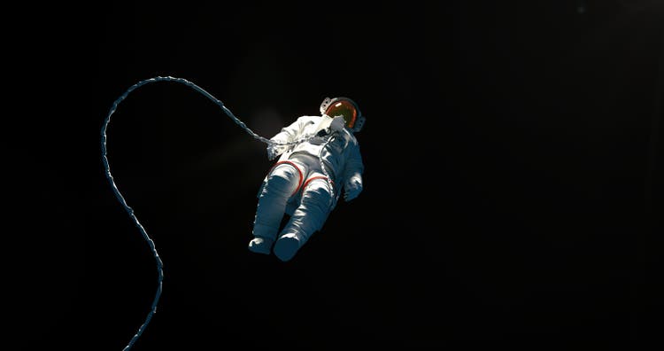 Hovering spaceman on a black background with a copy space for a astroscience topics and designs