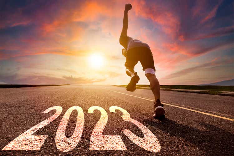 Young man running and sprinting on the road with new year 2023 concept