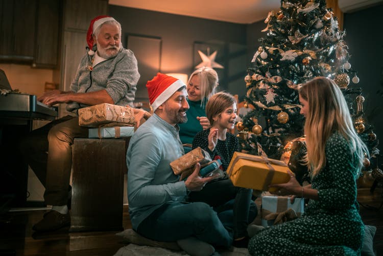 multigeneration family on the living room exchancing christmas presents