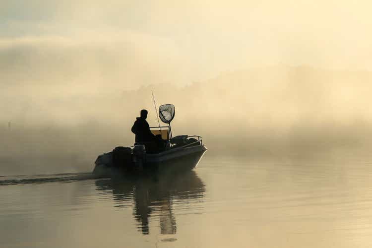 Early greeting fisherman with fog connected the lake.