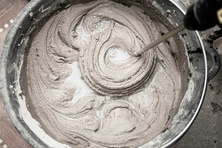 mixing cement adhesive with a mixer in a bucket close-up, texture of a mixed mortar