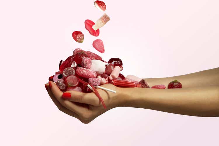 hand holding a bunch of red candy falling