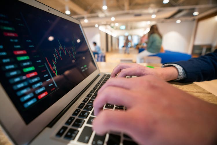 Close-up on a trader watching the stock market behavior on his laptop