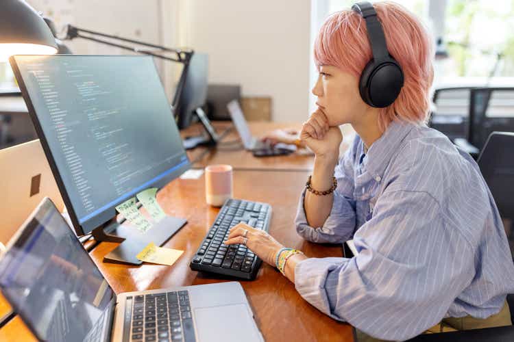 Businesswoman coding on computer at coworking office