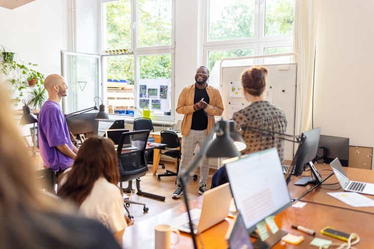 African man giving presentation to startup team at office